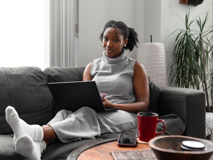 a-woman-using-a-laptop-while-sitting-on-a-couch