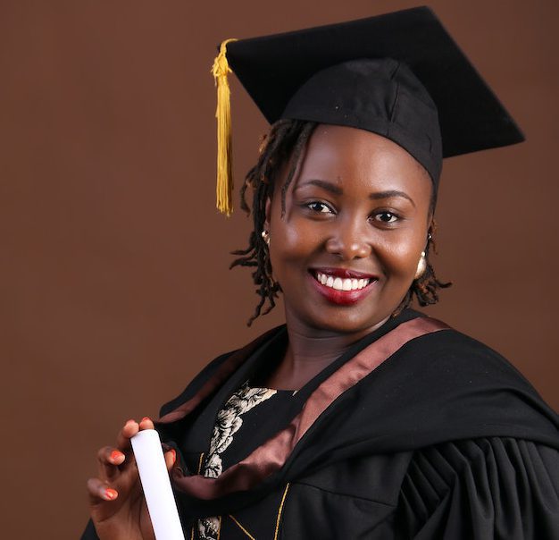 smiling-woman-in-academic-dress-holding-a-diploma