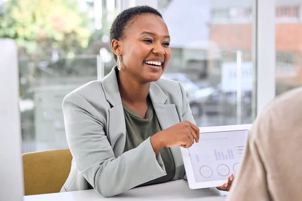 a businesswoman showing her colleague graphs on a digital tablet