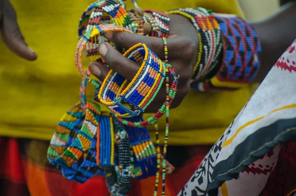 Close up hand of a Masai Woman selling handmade bracelets multi colored