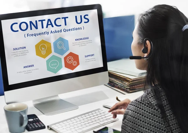 Businesswoman in call center working on computer with Concept Contact Us and FAQs