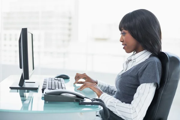 Smiling entrepreneur working on a computer in a bright office