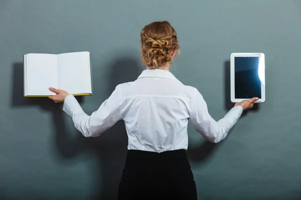 Woman holding traditional book and tablet, back view grunge background